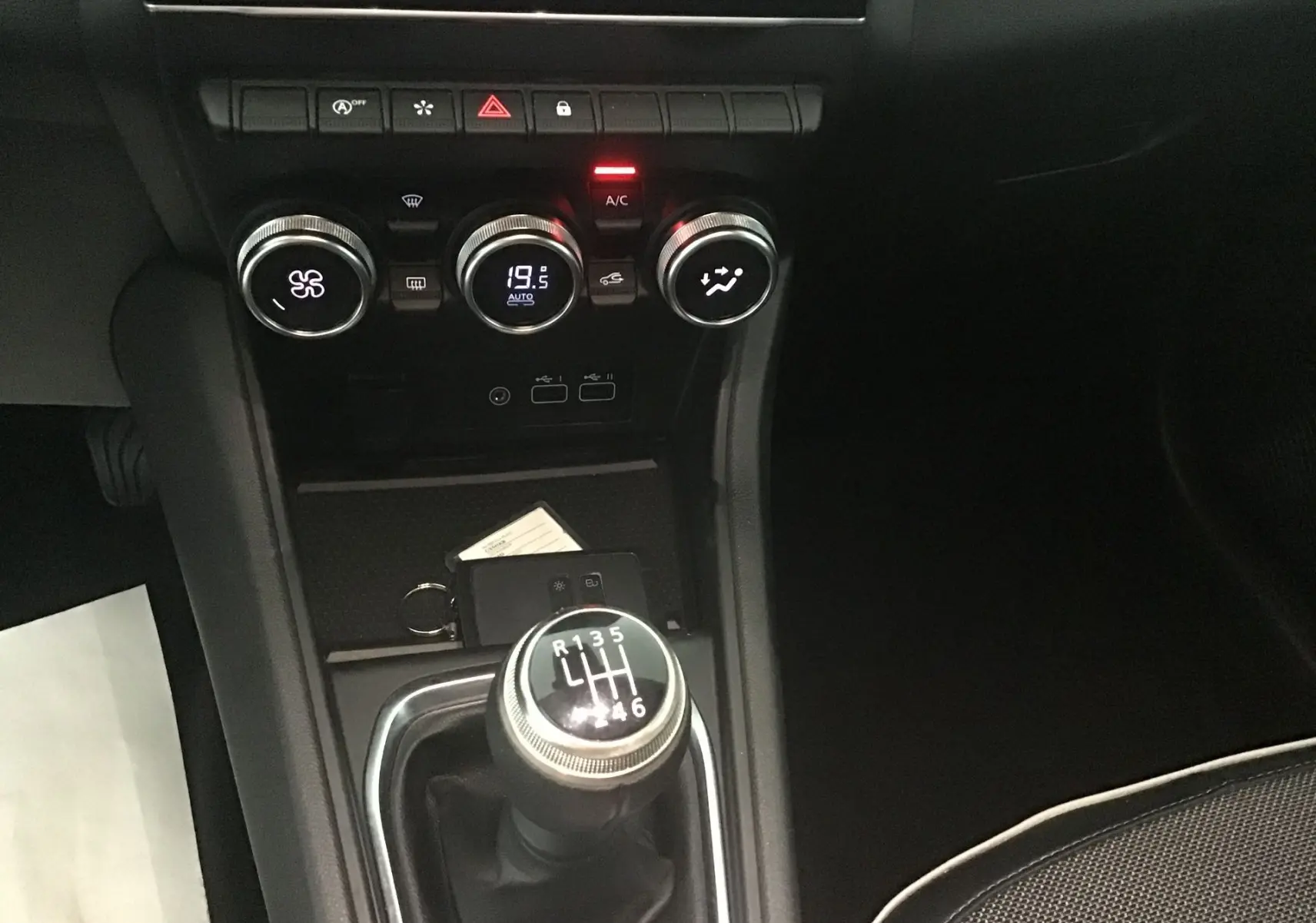 Vue rapprochée du levier de vitesses manuel et des commandes de climatisation du Renault Captur gris cassiopée 2024.