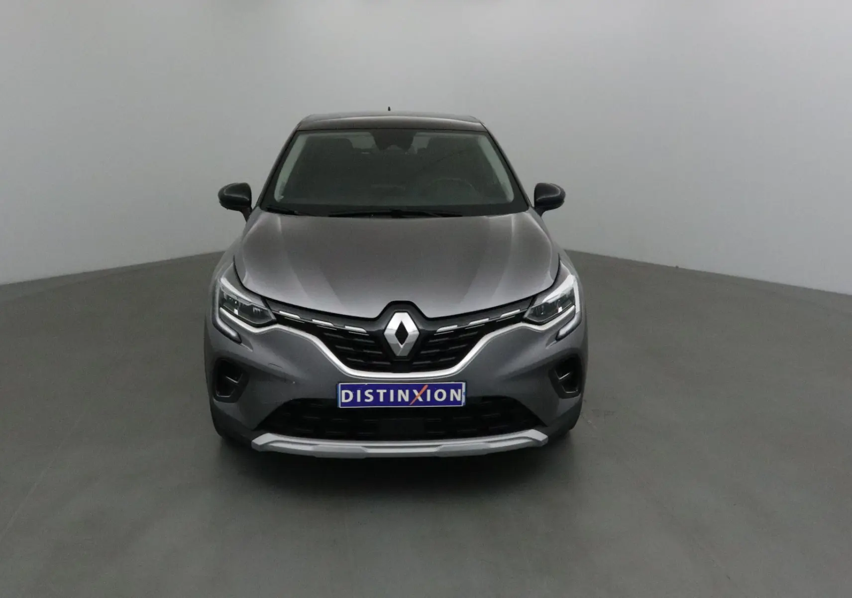 Renault Captur 2024 gris Cassiopée vue de face, avec logo Renault proéminent et plaque Distinxion.