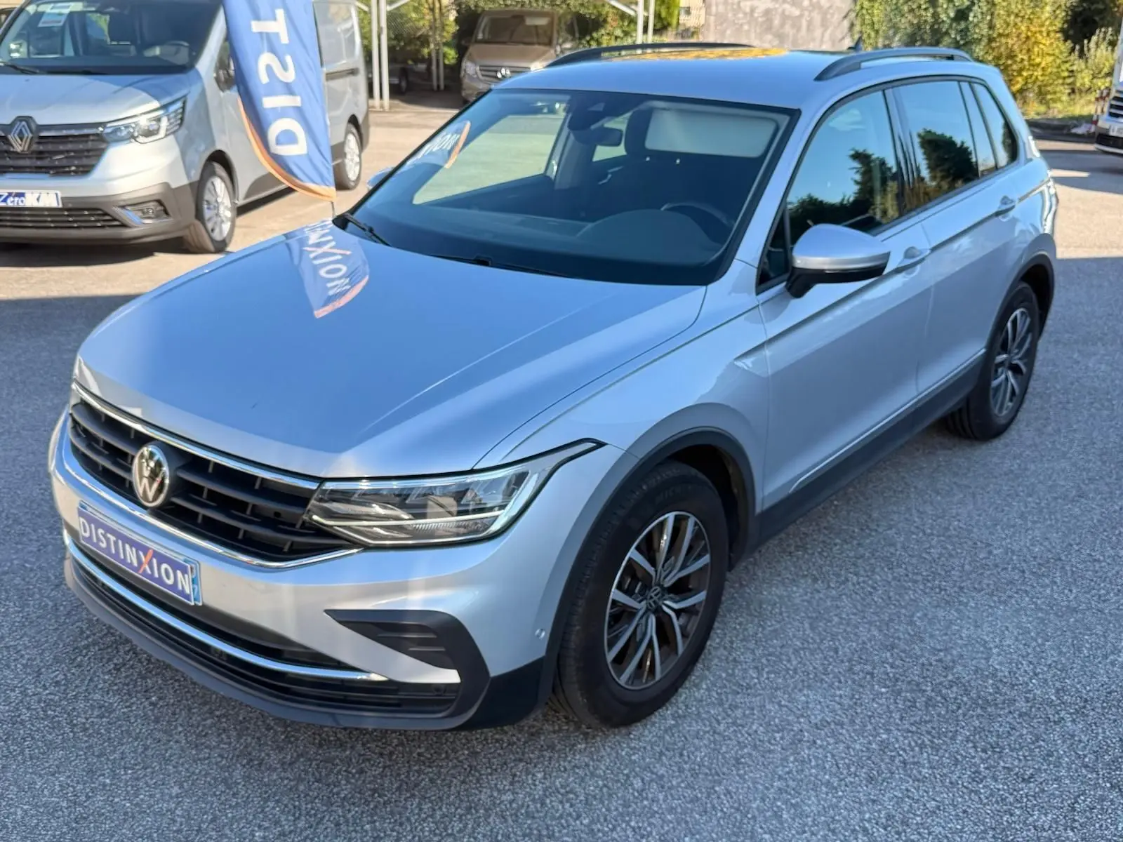 Volkswagen Tiguan 1.5 TSI 2021 en reflet argent, vue 3/4 avant droit avec calandre et phares LED distinctifs.
