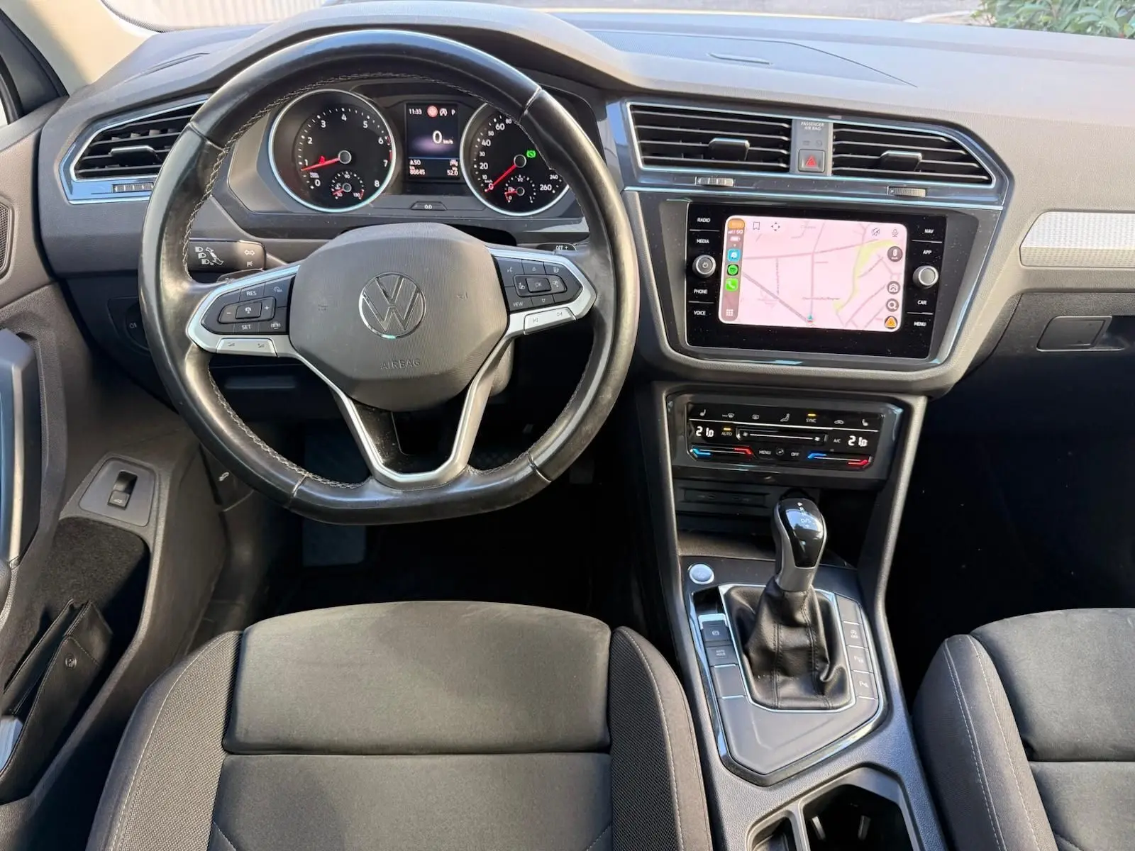 Vue intérieure du tableau de bord et volant noir d'un Volkswagen Tiguan 1.5 TSI 150CH LIFE DSG7 de 2021.