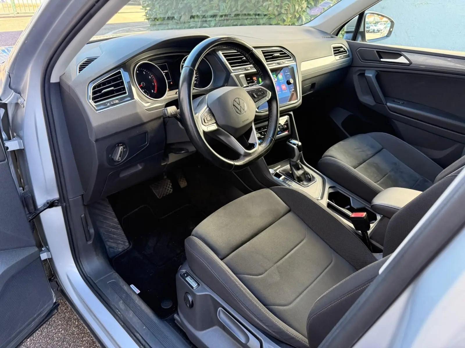 Intérieur avant droit du Volkswagen Tiguan 1.5 TSI 2021 en reflet argent, sièges Ergo Active et tableau de bord moderne.