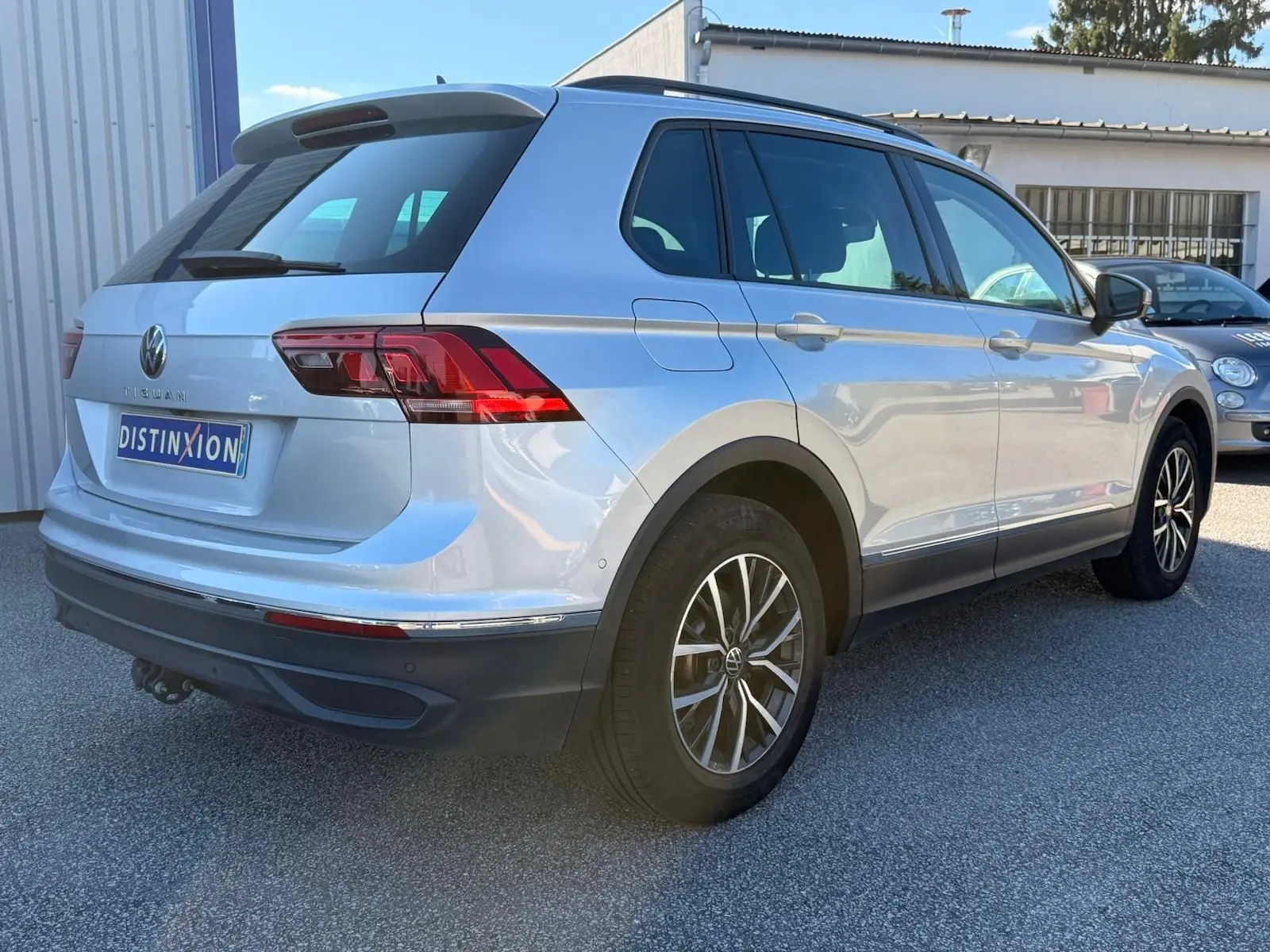 Volkswagen Tiguan 1.5 TSI argent en 3/4 arrière droit, avec jantes alliage et feux arrière LED distinctifs.