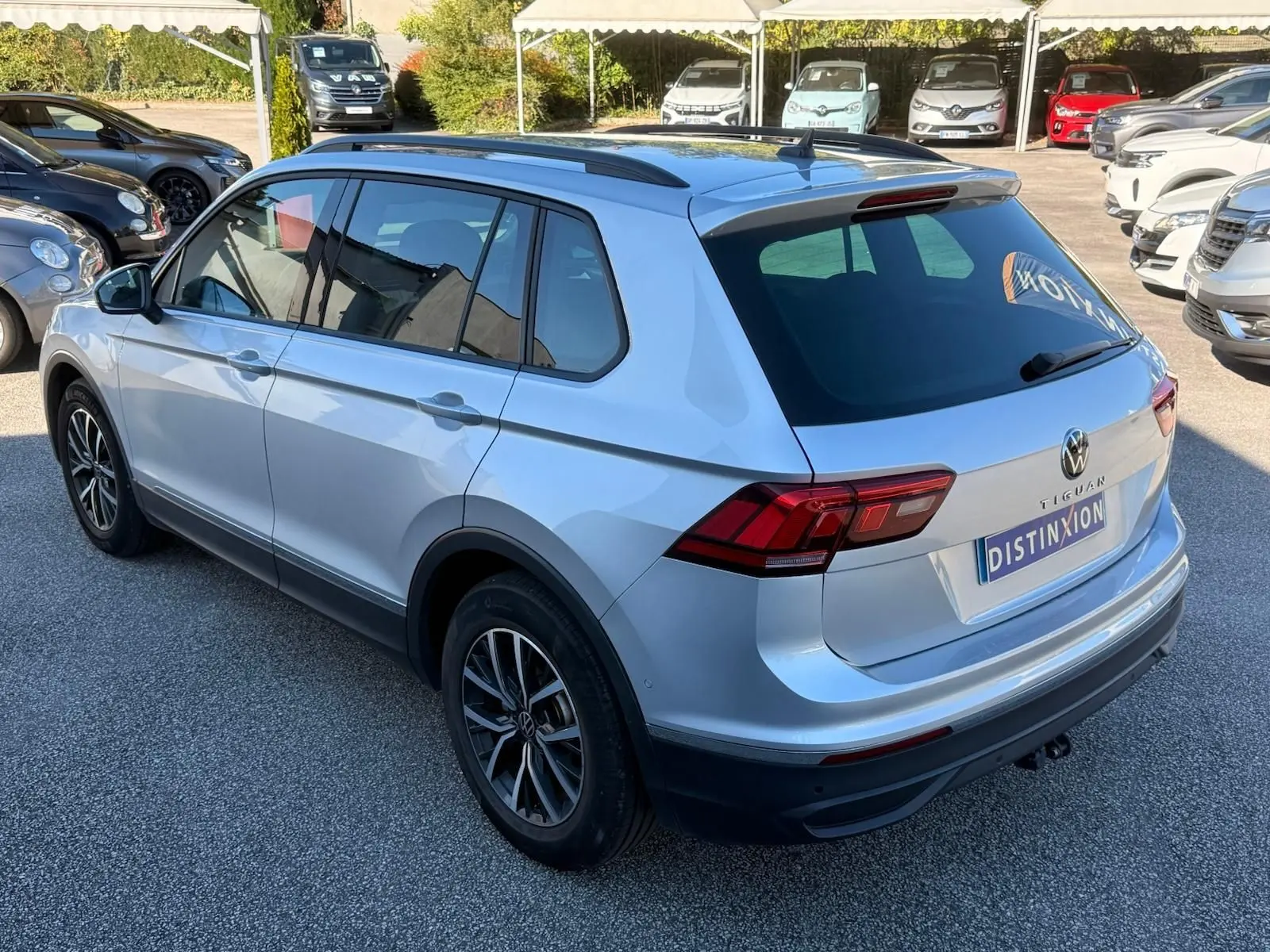 Volkswagen Tiguan 1.5 TSI 150ch Life argent reflet vu en 3/4 arrière droit sur parking extérieur.