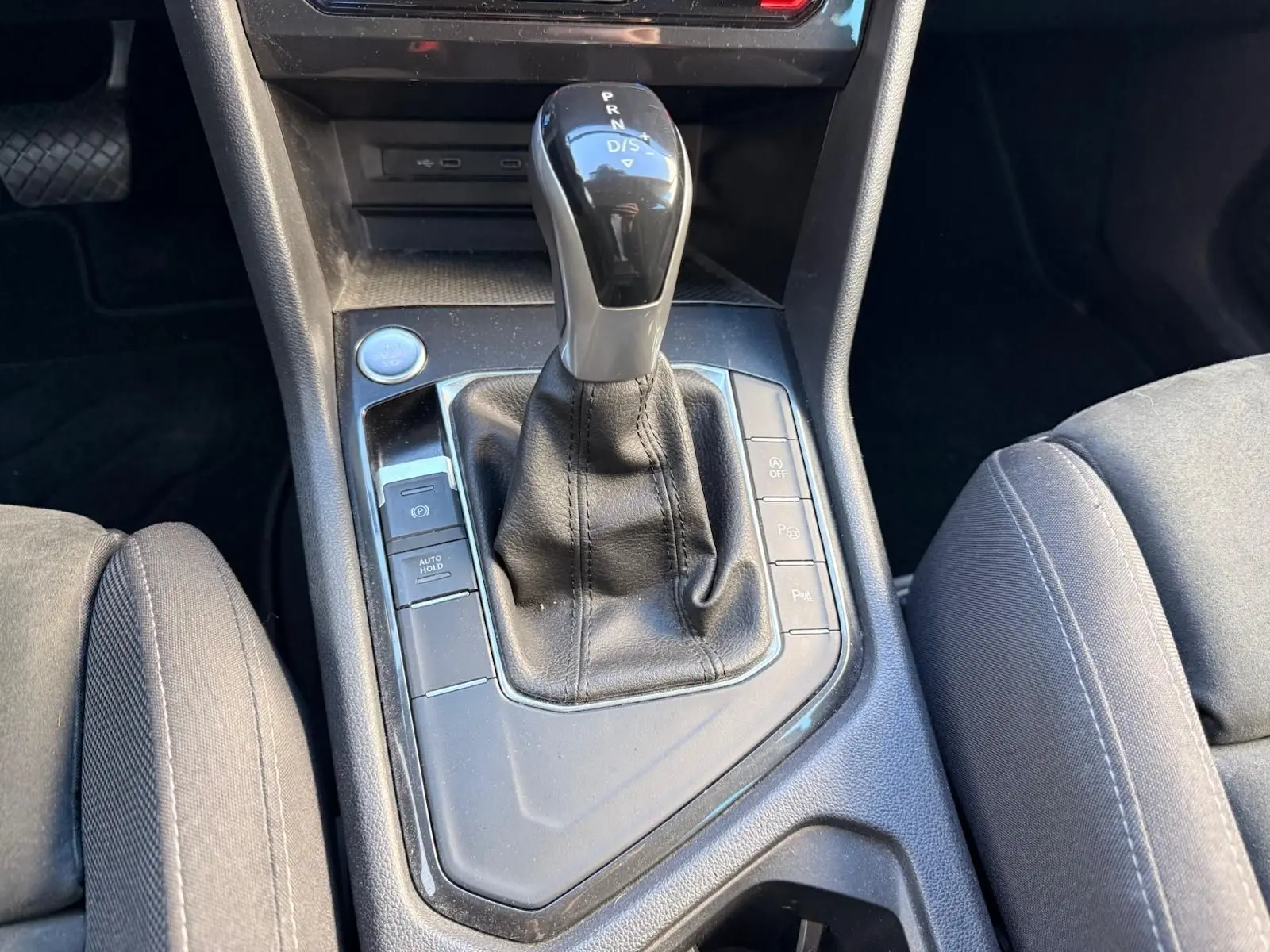 Le levier de vitesses automatique noir du Volkswagen Tiguan 1.5 TSI 150CH LIFE DSG7 vu en gros plan au centre console.