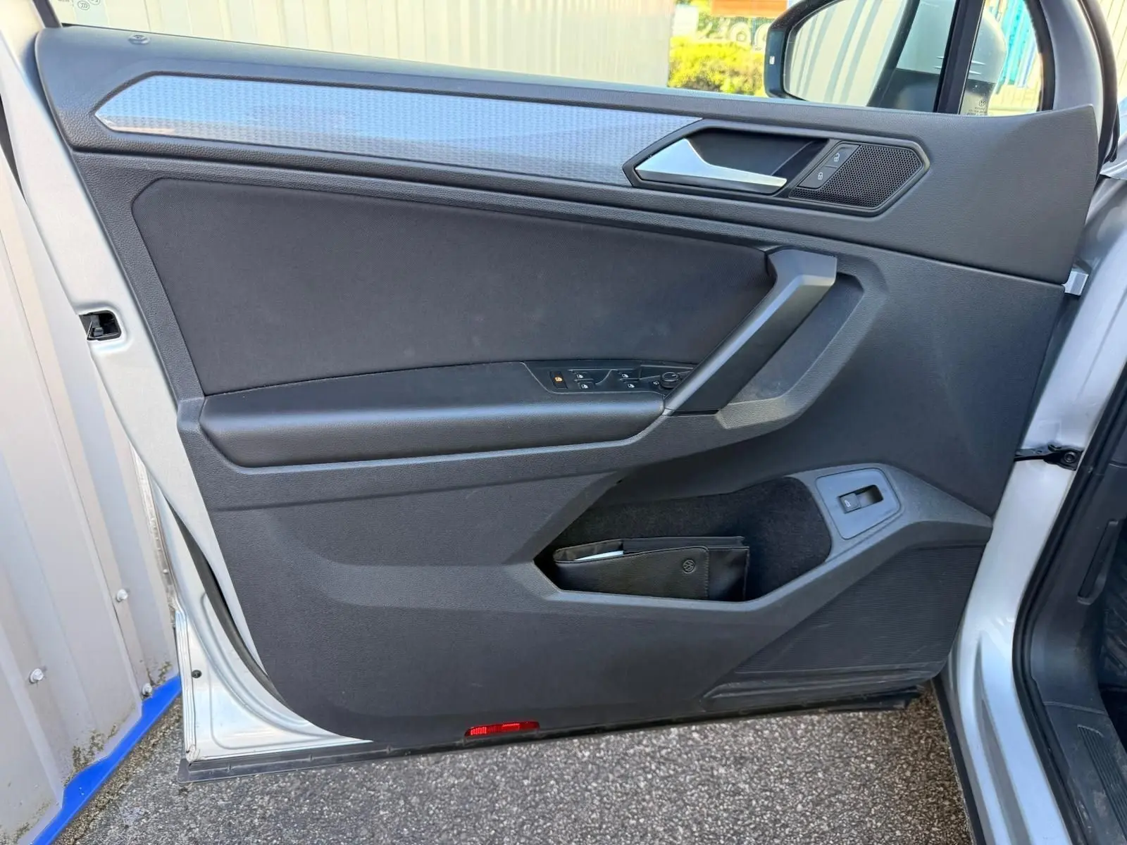 Vue rapprochée de la porte avant gauche du Volkswagen Tiguan 2021 en reflet argent avec garniture intérieure noire.