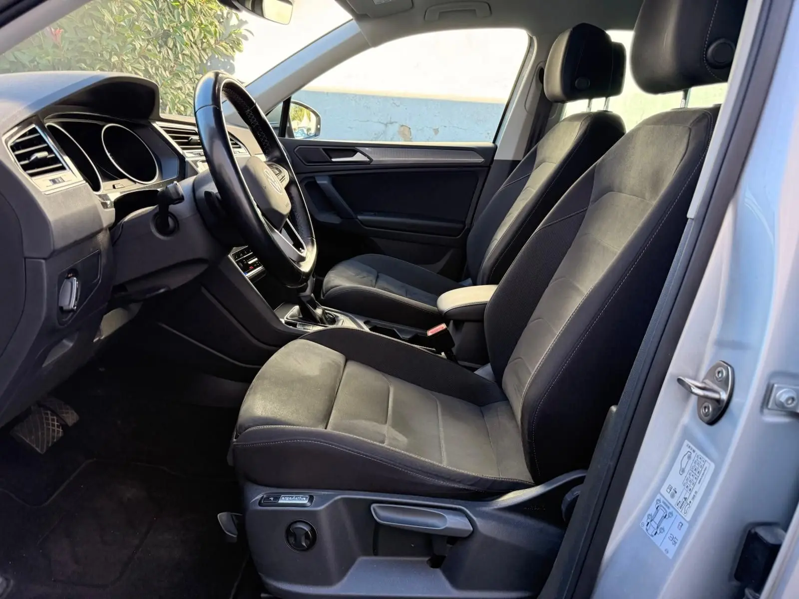 Intérieur côté conducteur du Volkswagen Tiguan 1.5 TSI 150CH Life 2021 avec sièges Ergo Active en tissu noir.