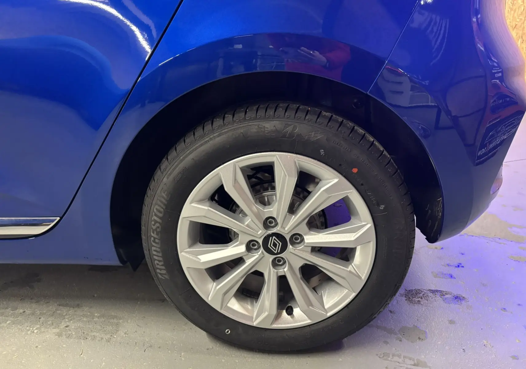 Gros plan sur la roue arrière droite de la Renault Clio TCE 90CH X-TRONIC Evolution bleu Iron avec jante alliage argentée.