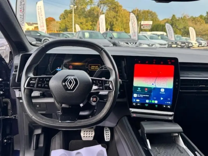 Intérieur du Renault Espace 2023 bleu nocturne, vue centrée sur le volant multifonction et l'écran tactile GPS vertical.