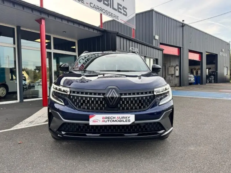 Vue de face du Renault Espace 1.2 E-Tech hybride bleu nocturne avec calandre noire et phares LED matrix visibles.