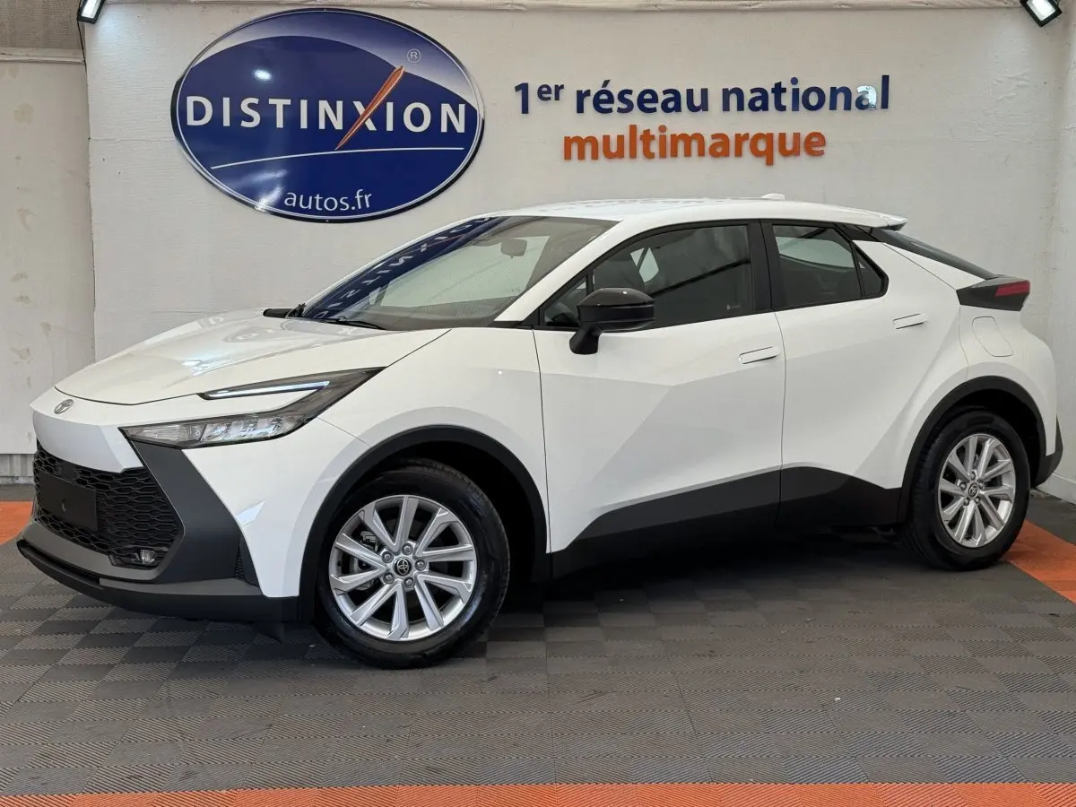 Vue de profil côté gauche du Toyota C-HR 1.8 Hybride blanc 2024 avec lignes anguleuses et jantes alliage.
