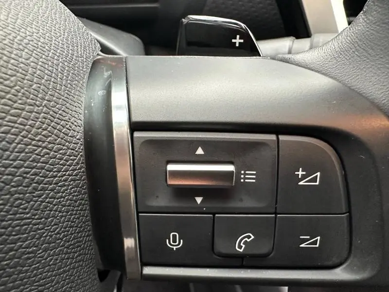 Détail du volant côté gauche du Citroën C4 X 2025 gris Mercury, montrant les commandes audio et téléphone.
