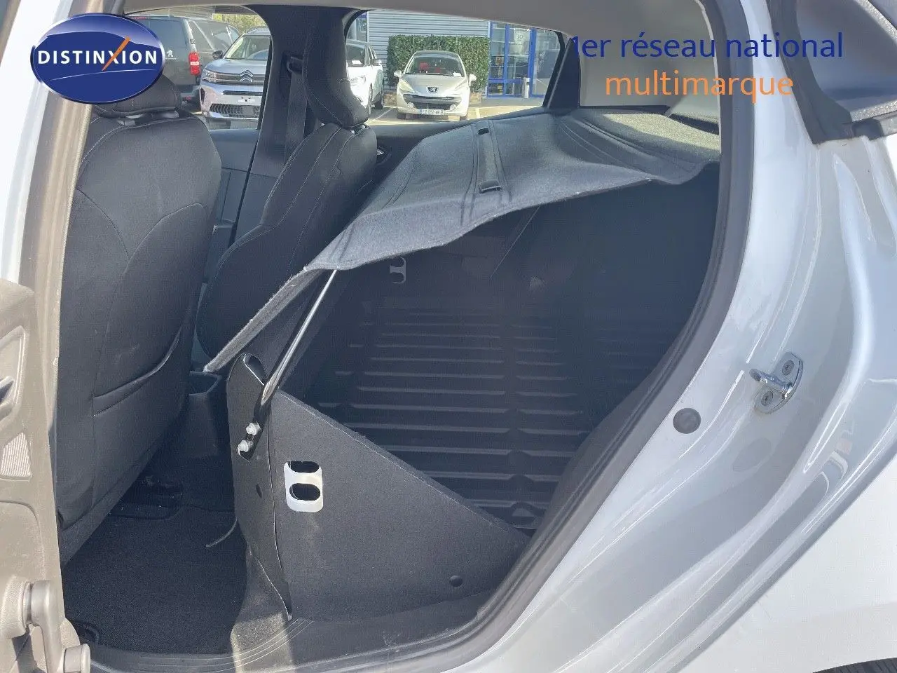 Vue côté droit arrière d'une Renault Clio Société blanche avec banquette relevée et espace de chargement visible.