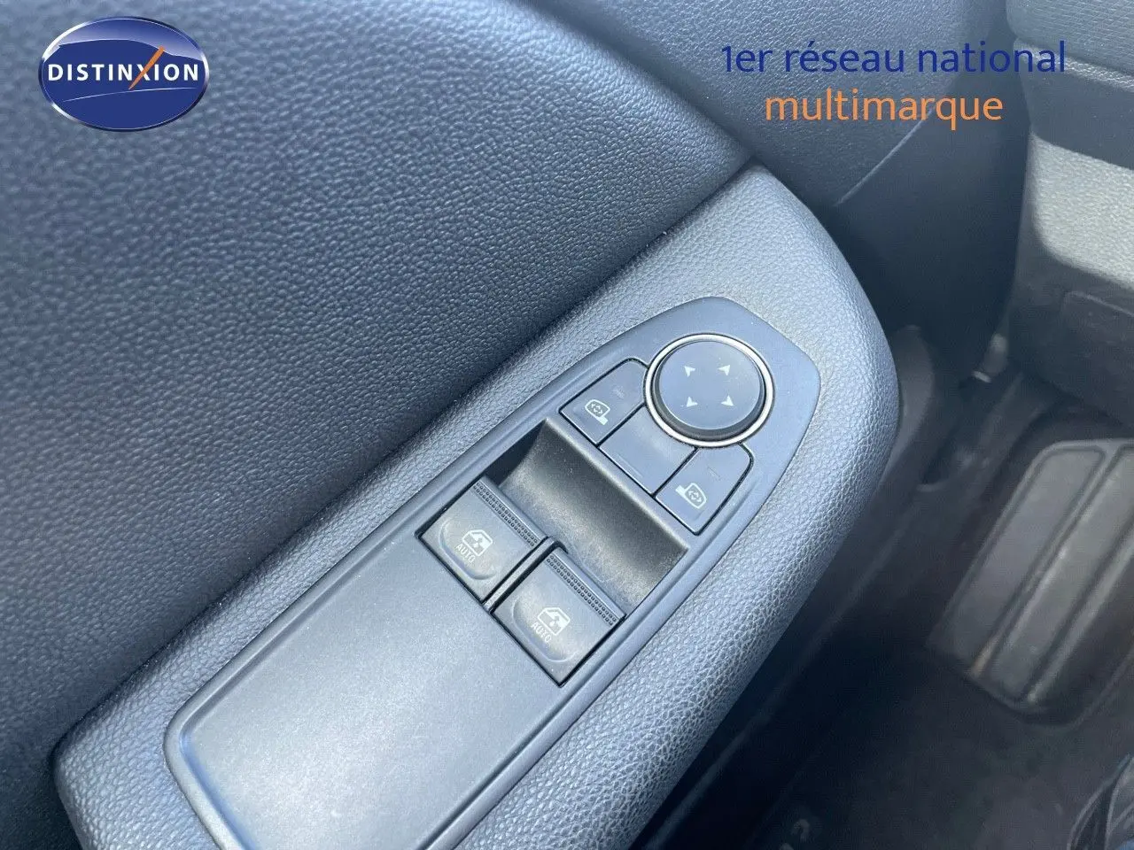 Gros plan sur les commandes des vitres électriques côté conducteur d'une Renault Clio Société blanc glacier, intérieur noir.