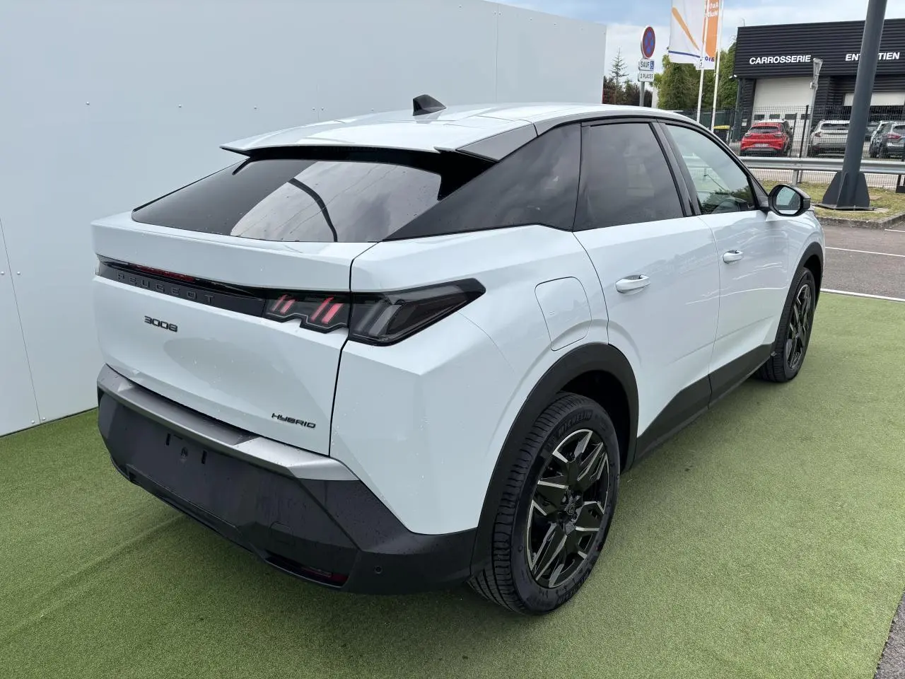 Vue 3/4 arrière droit du Peugeot 3008 blanc Okenite 2024 avec feux arrière LED 3 griffes et jantes alliage 19 pouces noires.