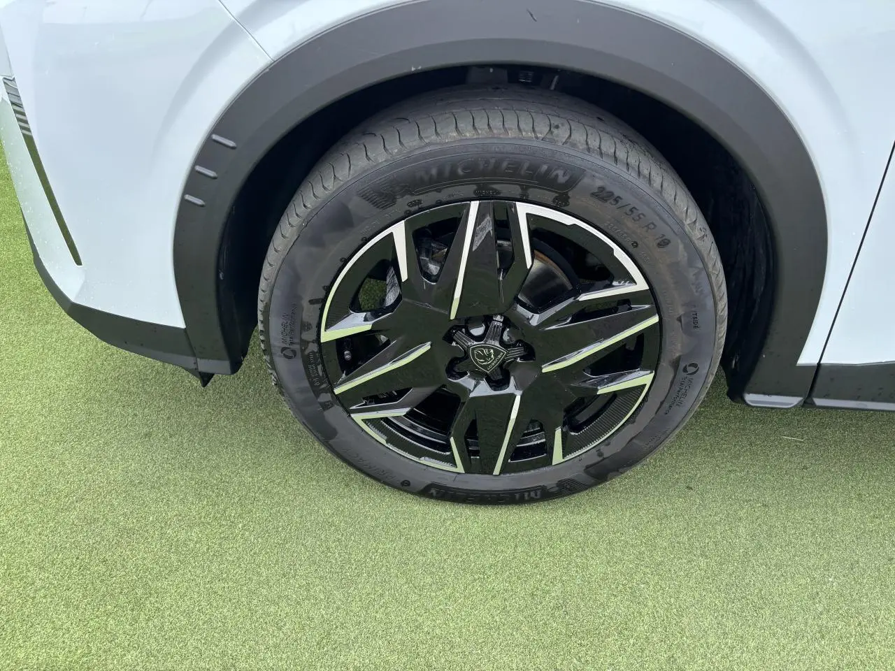 Gros plan sur la roue avant gauche noire et argentée du Peugeot 3008 blanc Okenite 2024.