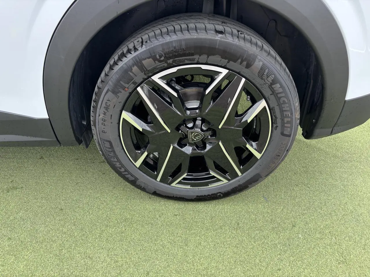 Gros plan sur la roue avant droite du Peugeot 3008 blanc Okenite avec jante alliage 19'' noire et diamantée.
