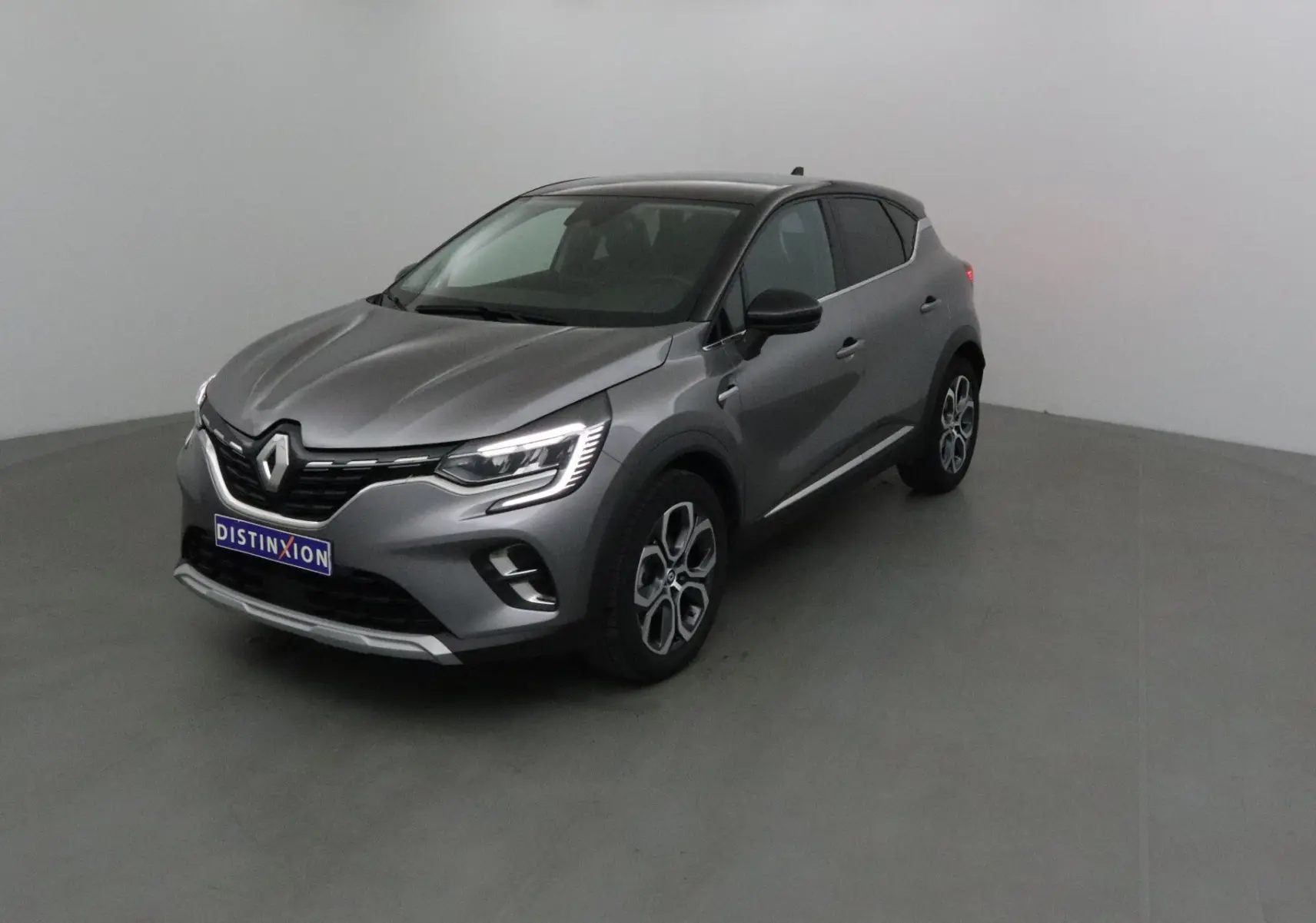 Renault Captur 2024 gris Cassiopée avec toit noir, vue 3/4 avant droit dans un studio neutre.