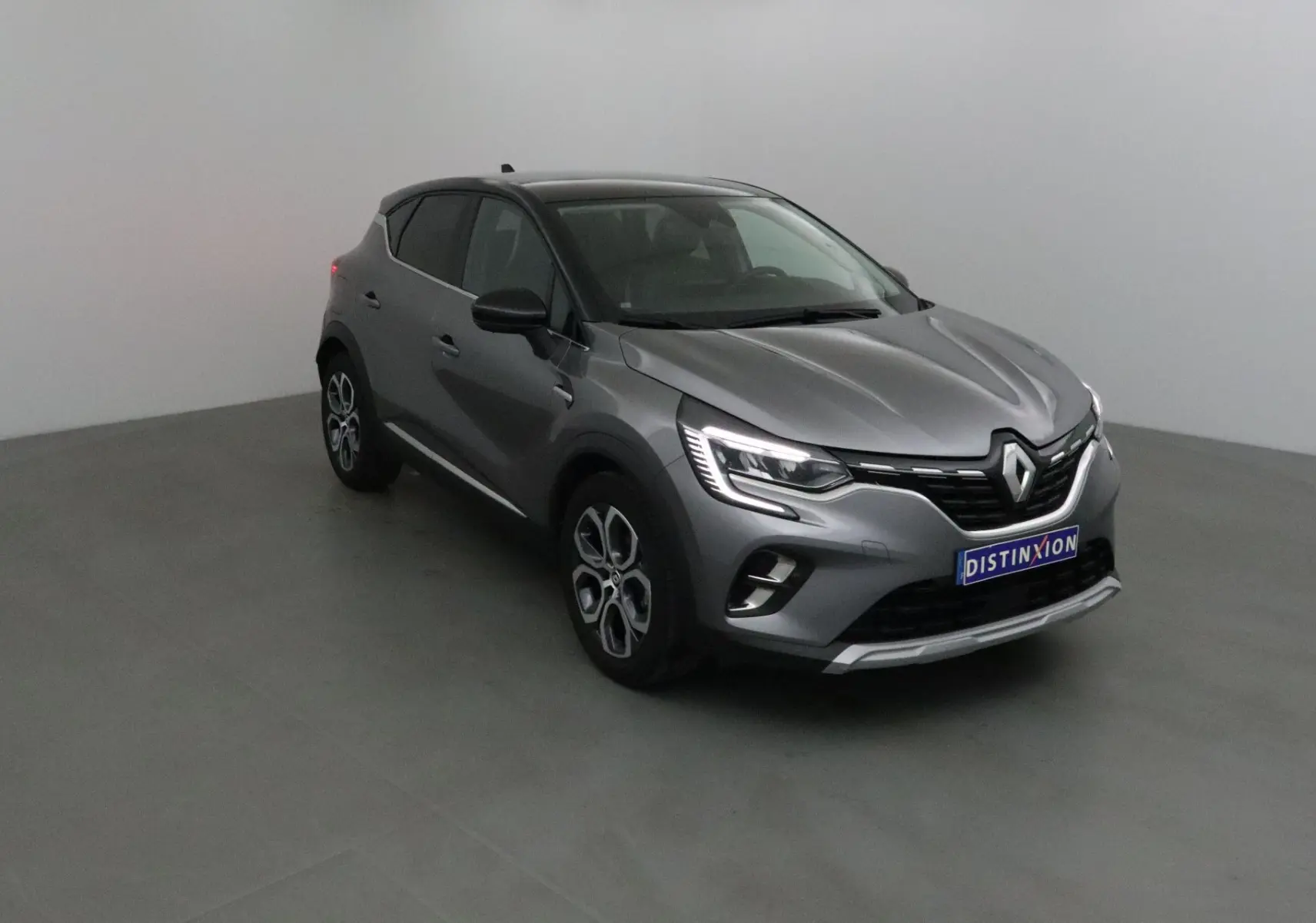 Renault Captur gris Cassiopée avec toit noir, vue 3/4 avant droit, feux LED et jantes alliage 18 pouces.