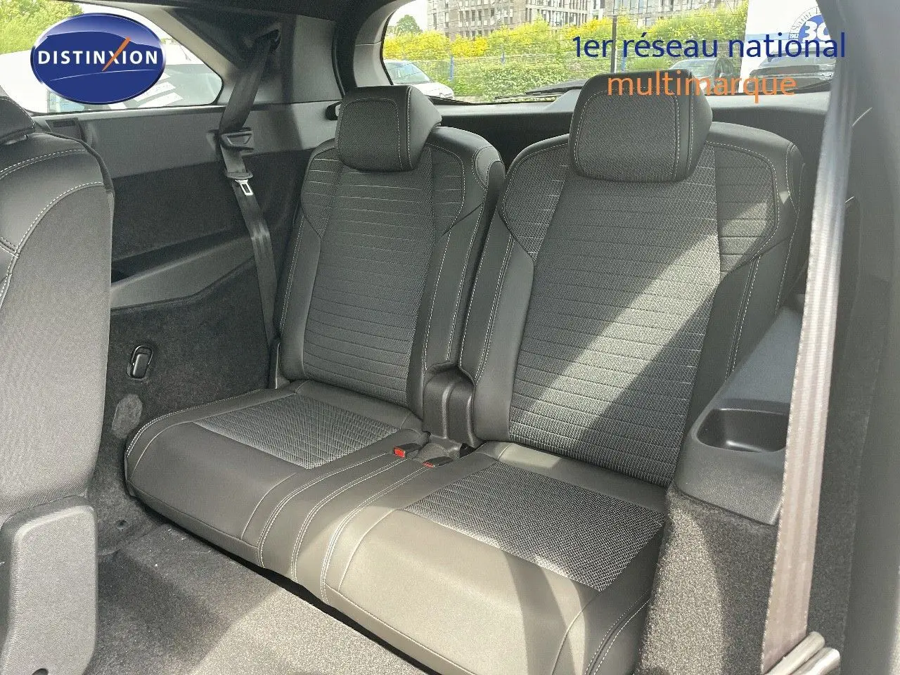 Vue intérieure sur la troisième rangée de sièges noirs en cuir et tissu du Peugeot 5008 Hybrid 2025.