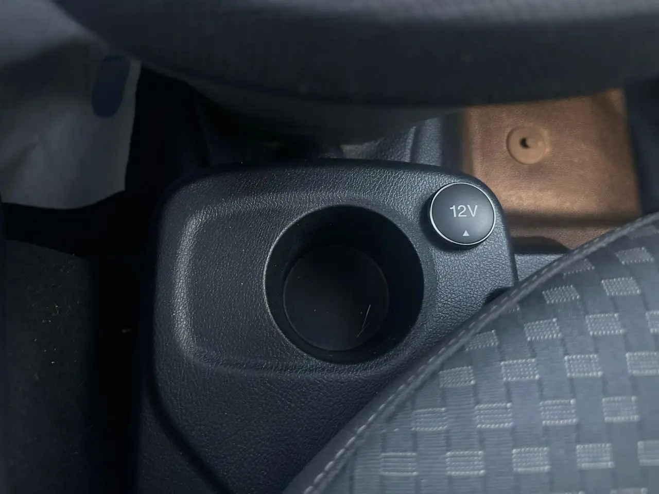 Gros plan sur la prise 12V et porte-gobelet noir dans l'habitacle du Ford Transit Connect blanc de 2019.