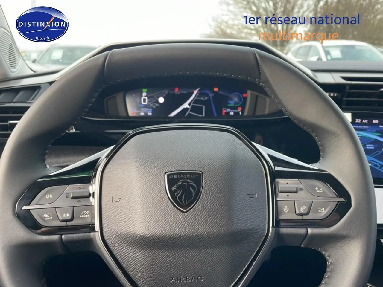 Vue rapprochée du volant noir multifonction de la Peugeot 308 1.2 hybrid 145 allure e-dcs6 avec tableau de bord numérique.