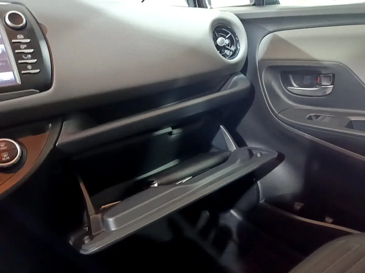 Vue intérieure côté passager de la Toyota Yaris 1.5 Hybride 2020, boîte ouverte avec tableau de bord noir.