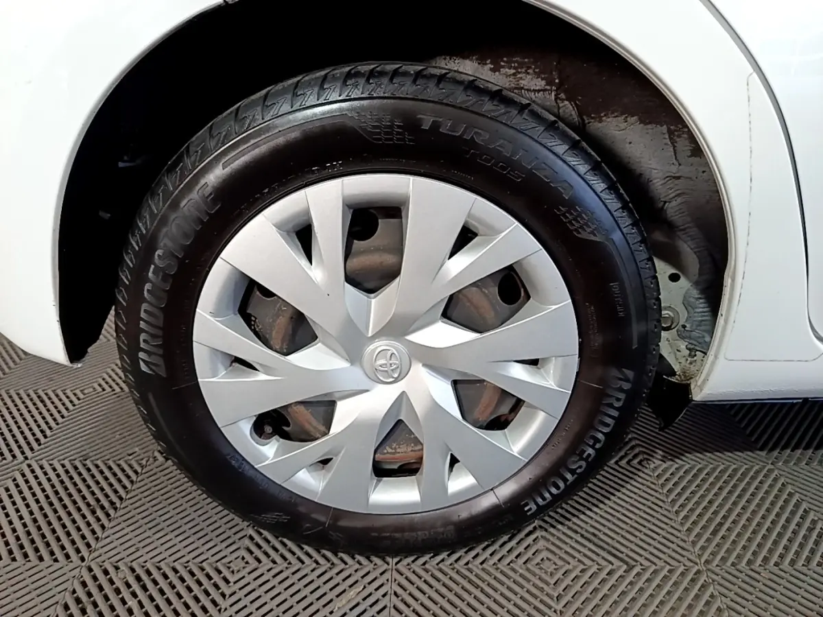 Gros plan sur la roue avant droite blanche d’une Toyota Yaris 1.5 Hybride avec enjoliveur argenté et pneu Bridgestone.