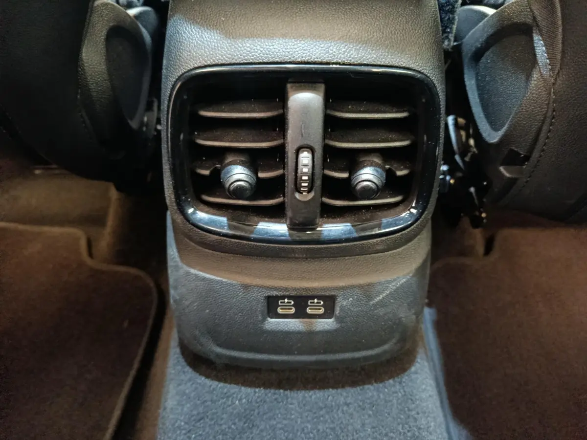 Vue rapprochée des bouches d’aération arrière et ports USB noirs du MINI Countryman gris foncé, intérieur au sol sombre.