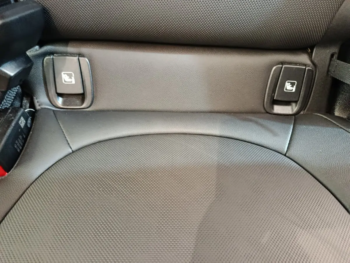 Gros plan sur la banquette arrière en cuir noir du MINI Countryman 2023, avec commandes rabattage sièges visibles.