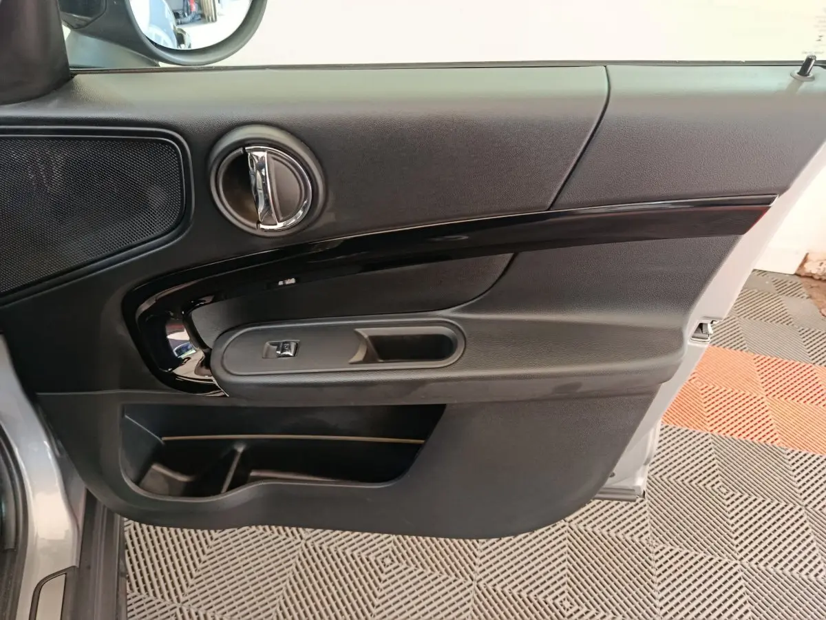 Vue rapprochée de la porte avant gauche gris foncé du MINI Countryman Cooper Edition Premium Plus 2023 avec poignée et commande de vitre.