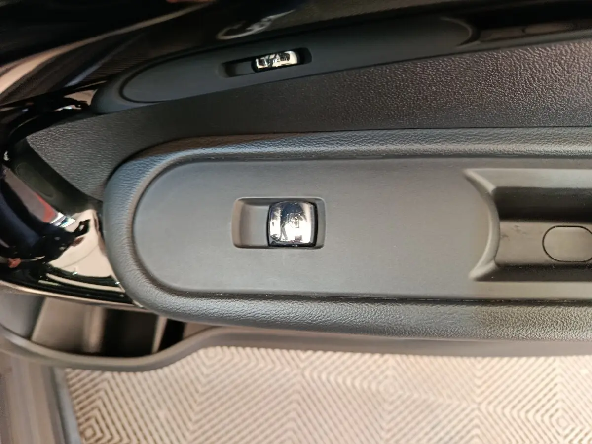Gros plan sur la commande de verrouillage centralisé sur la portière côté conducteur d’un MINI Countryman gris foncé.