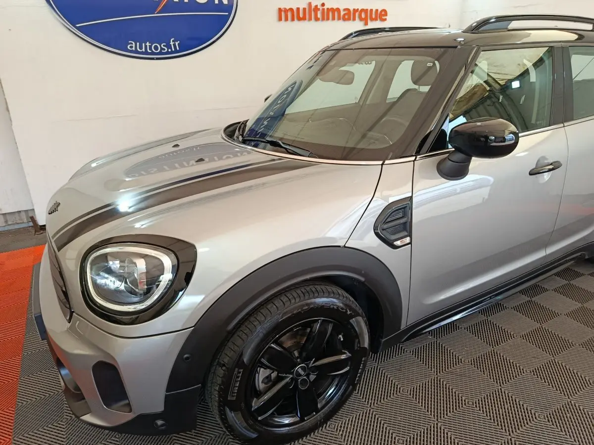 Vue 3/4 avant droit d'une MINI Countryman gris foncé avec jantes noires et toit noir brillant.