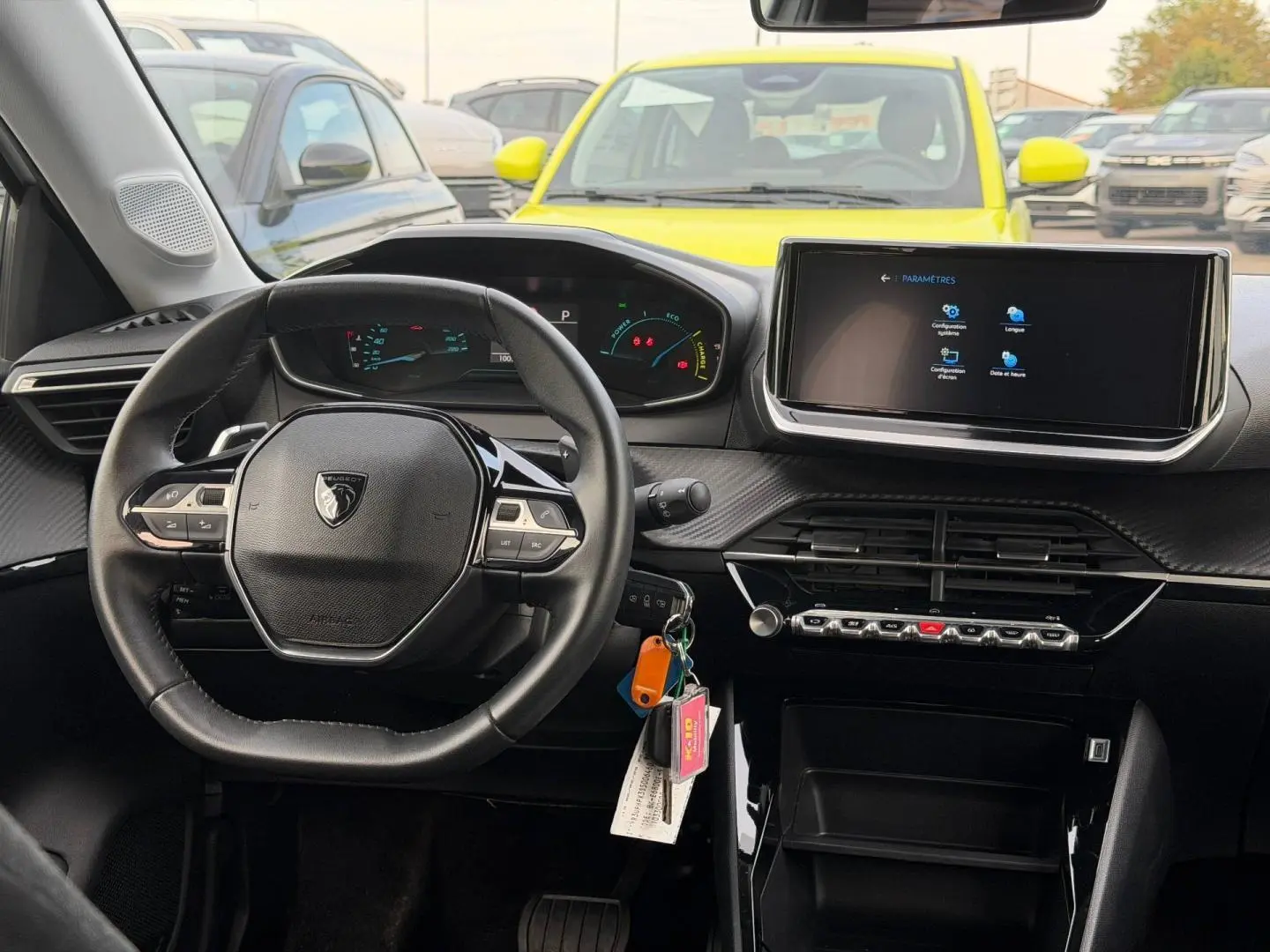 Intérieur Peugeot 208 2025 vu du poste de conduite, volant compact, tableau de bord numérique et écran tactile central.