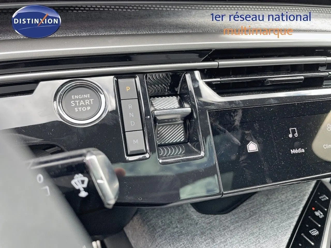 Détail du tableau de bord du Peugeot 5008 Hybrid 2025 avec bouton start/stop et commande de boîte automatique en finition noire brillante.