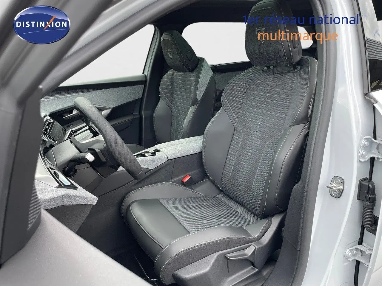 Vue intérieure côté conducteur du Peugeot 5008 Hybrid 2025 avec sièges en cuir noir et tissu gris.