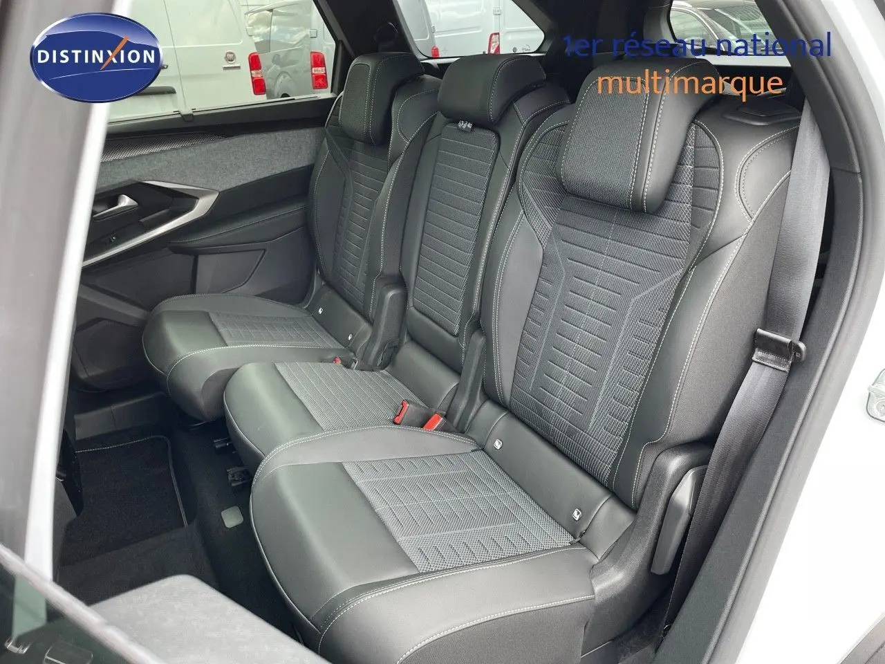 Vue intérieure côté droit sur les sièges arrière en cuir noir du Peugeot 5008 Hybrid 2025 blanc toit noir.