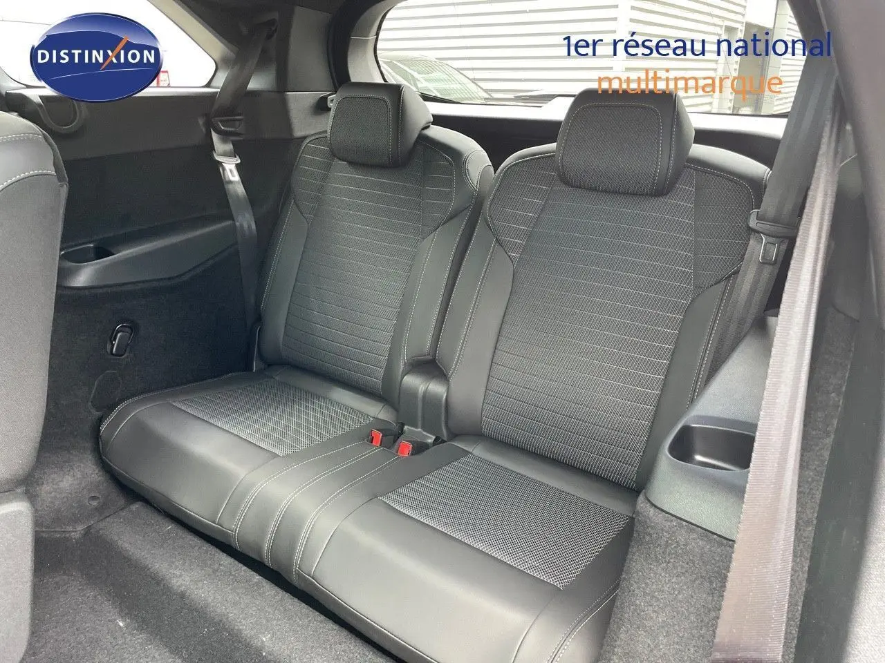 Vue intérieure sur la banquette arrière en cuir noir du Peugeot 5008 Hybrid 2025 avec ceinture de sécurité visible.