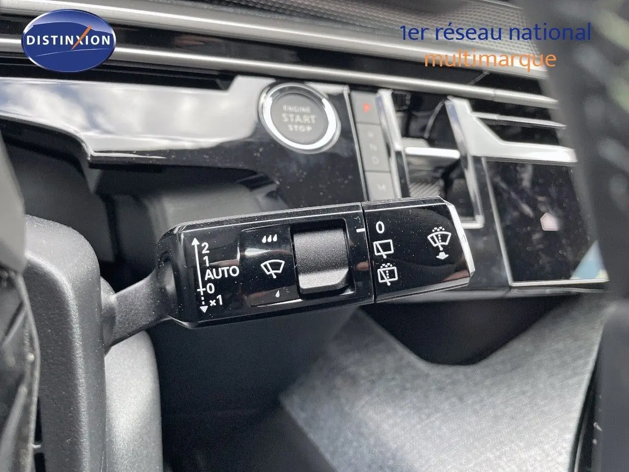 Gros plan sur la commande des essuie-glaces du Peugeot 5008 Hybrid 2025 avec tableau de bord noir brillant en arrière-plan.