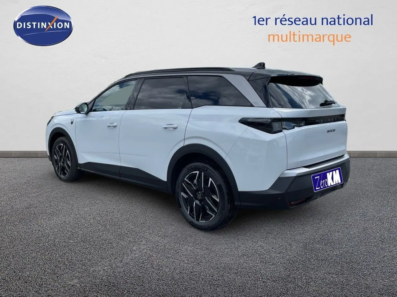 Peugeot 5008 Hybrid blanc Okenite avec toit noir, vue 3/4 arrière côté gauche, jantes noires distinctives.