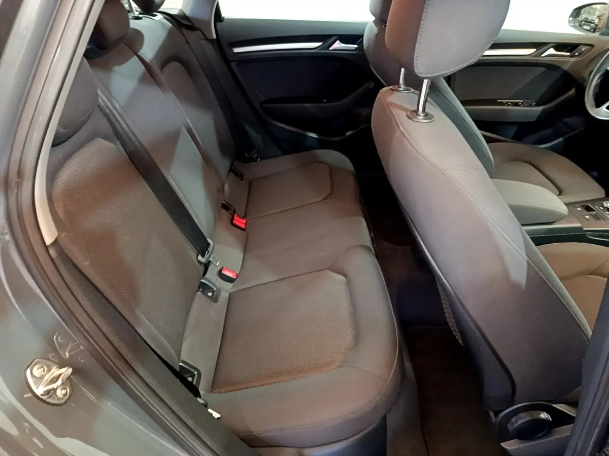 Vue intérieure côté gauche montrant la banquette arrière grise et les sièges avant de l'Audi A3 30 TDI 2019.
