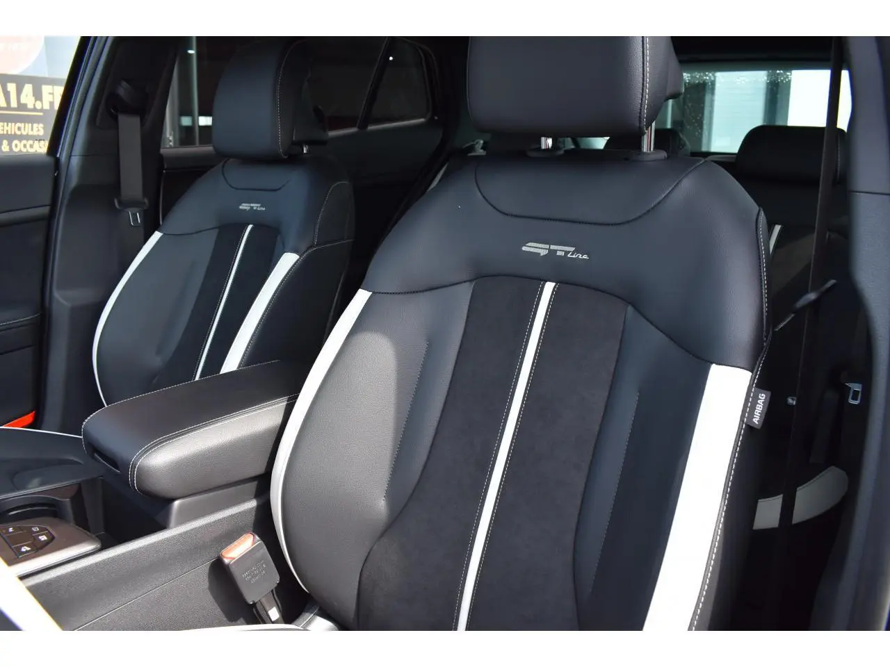 Gros plan sur les sièges avant bi-ton noir et gris du Kia Sportage hybride 2026 version GT-Line.