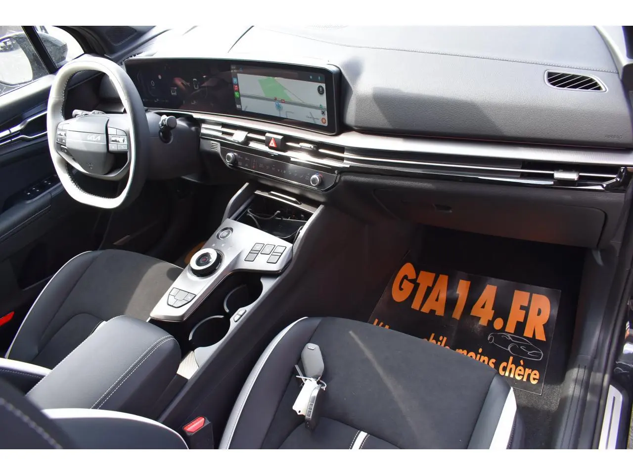 Intérieur avant droit du Kia Sportage 2026 hybride noir, avec tableau de bord digital et console centrale moderne.