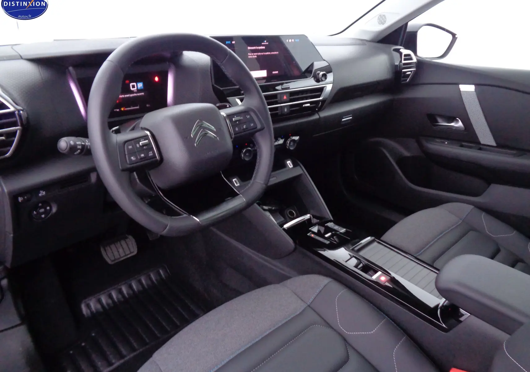 Intérieur moderne de la Citroën C4 X 2023, vue côté conducteur, avec tableau de bord numérique et sellerie noire.