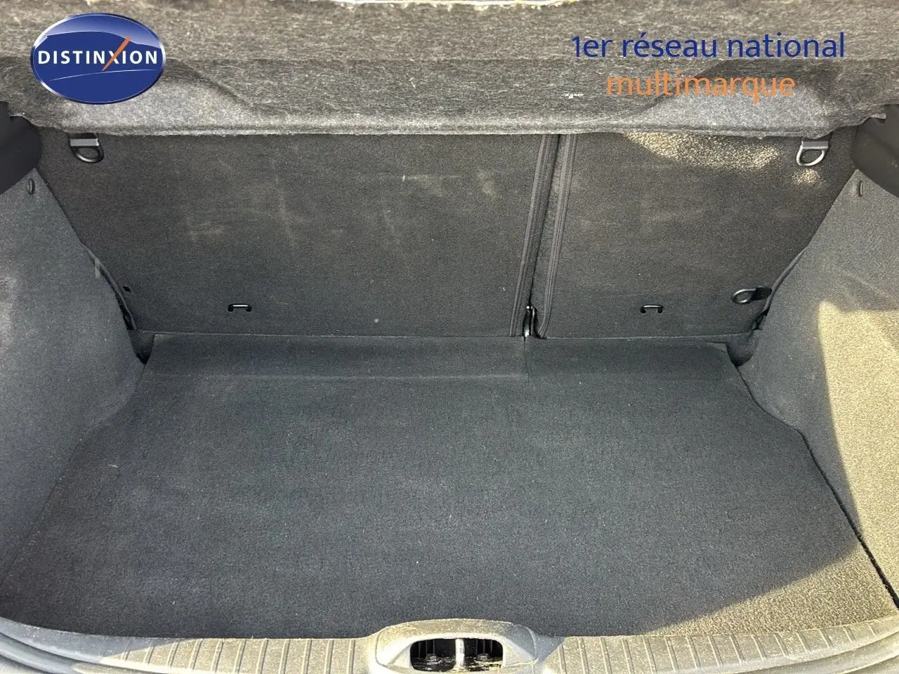 Coffre vide en tissu gris foncé d'une Peugeot 208 noire perle métal vue de l'arrière avec hayon ouvert.