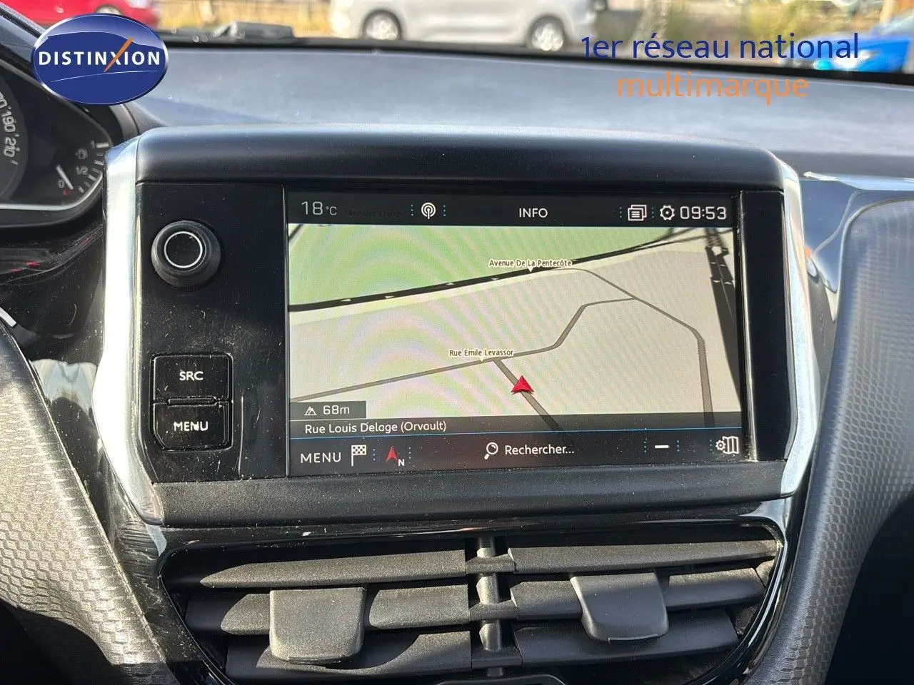 Écran tactile du système de navigation de la Peugeot 208 noire, vue centrale du tableau de bord avec commandes et ventilation.