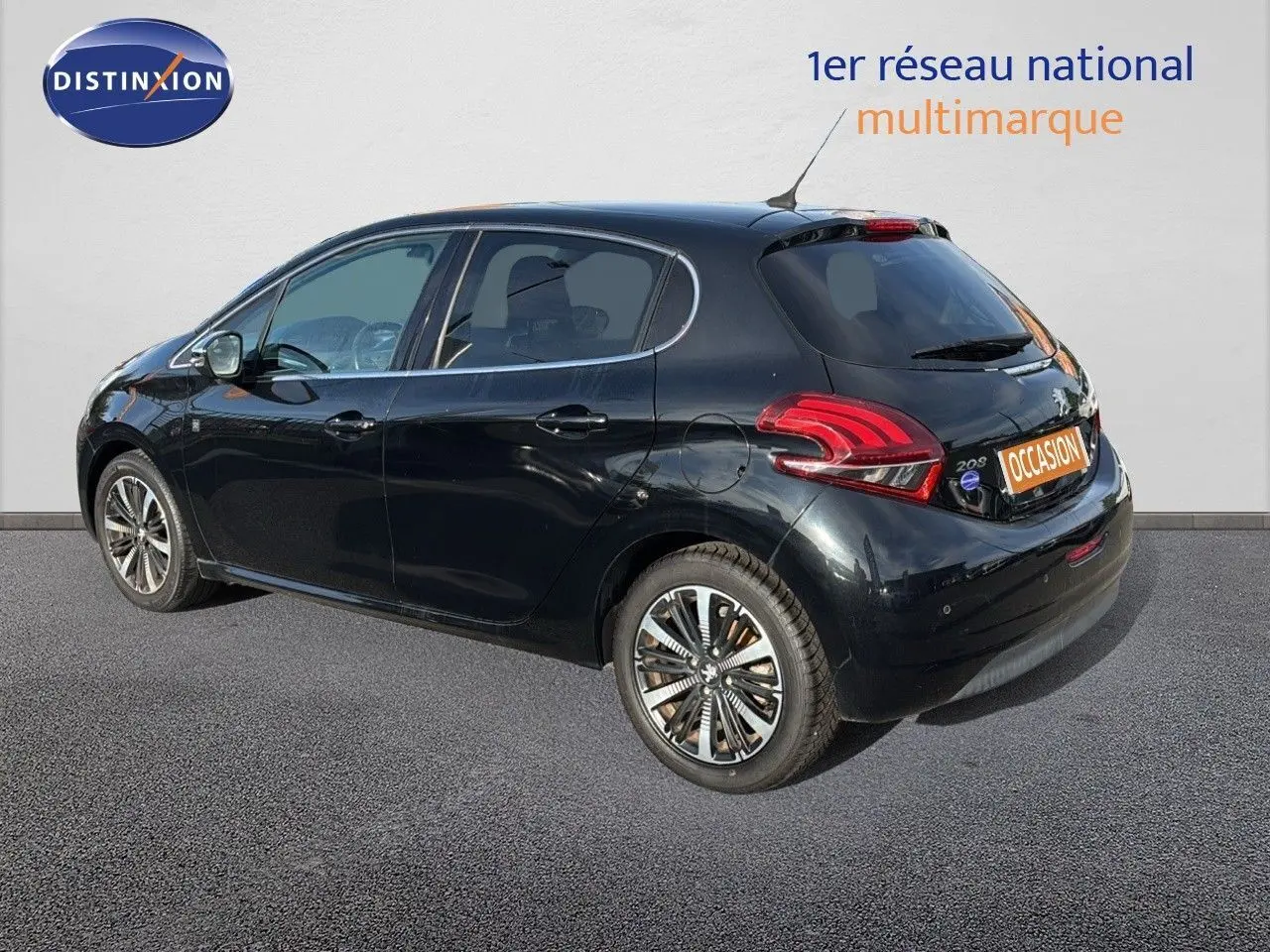 Peugeot 208 noir perle métal vue de trois quarts arrière côté gauche, avec jantes alliage et feux arrière LED.