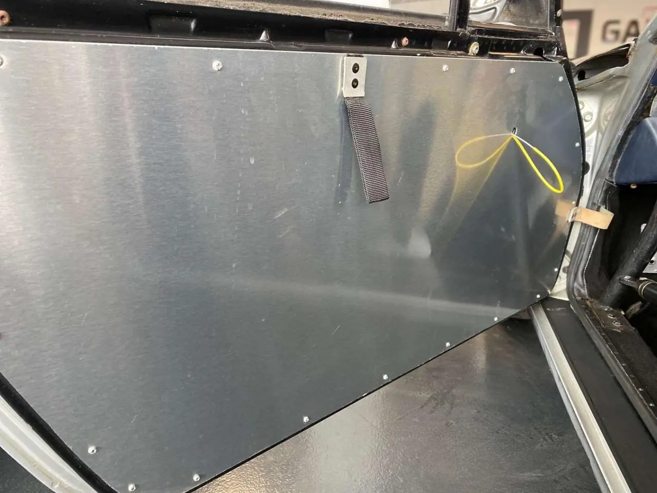 Vue rapprochée de la contre-porte en aluminium côté gauche d'une Porsche 911 3.0 SC gris métallisé de 1980, intérieur course.