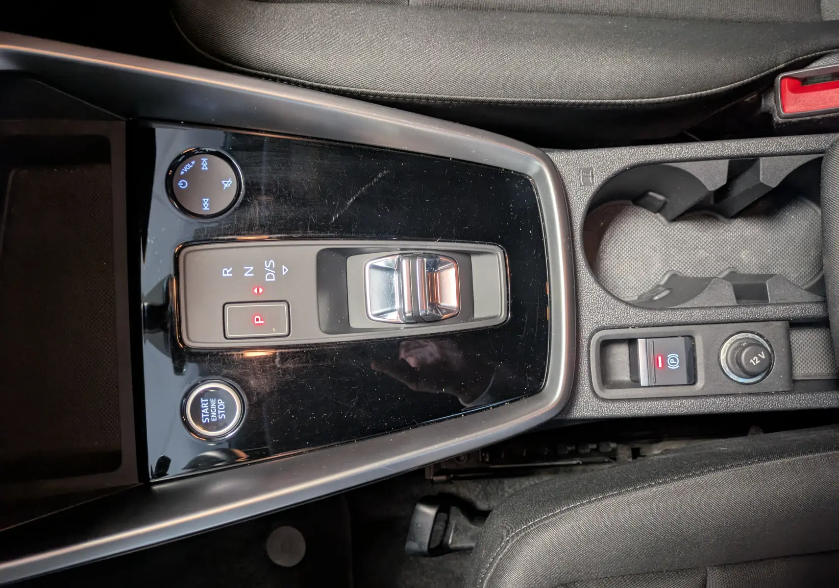 Vue plongeante sur la console centrale noire brillante de l'Audi A3 Sportback 35 TDI avec levier de vitesses automatique et bouton start/stop.