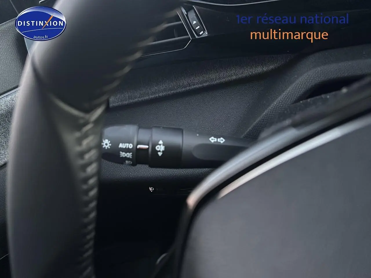 Gros plan sur la commande des feux et clignotants derrière le volant d'une Peugeot 308 gris Artense 2025.