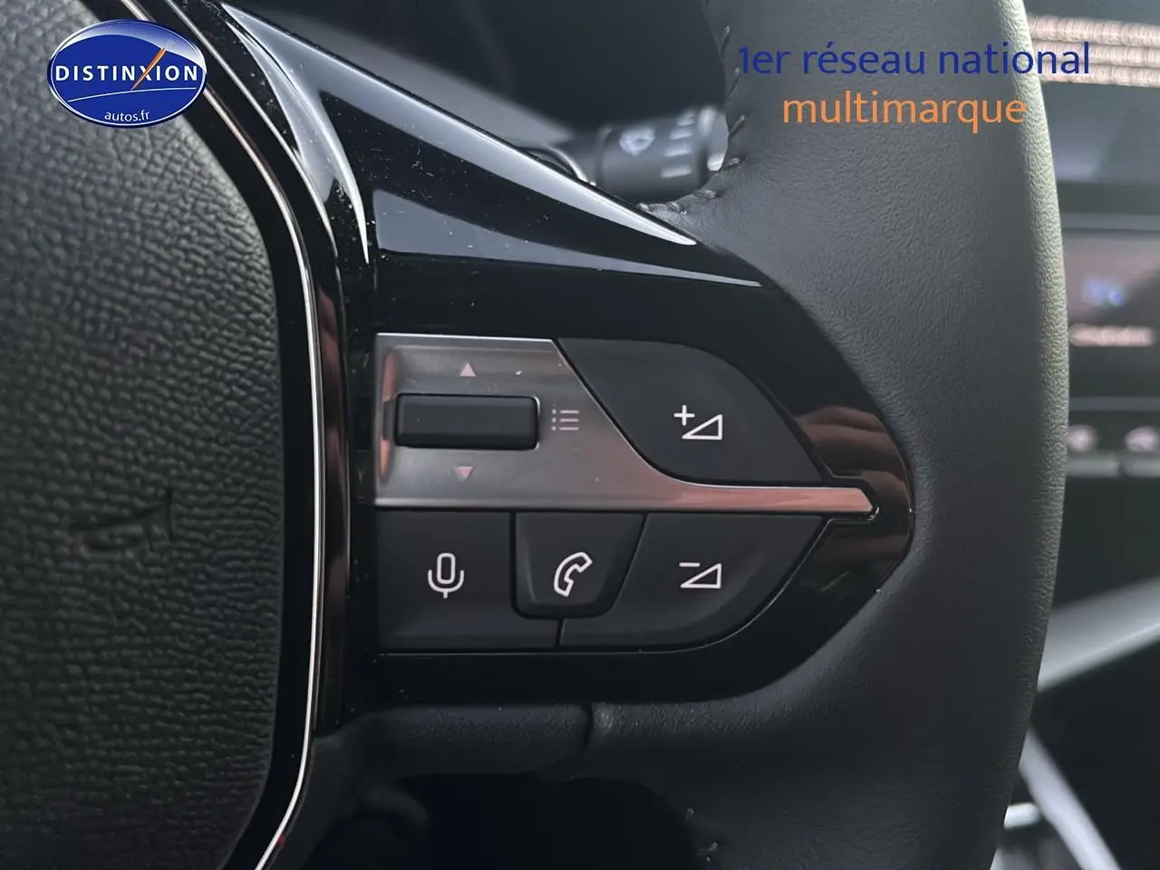 Gros plan sur les commandes multifonctions du volant côté gauche d'une Peugeot 308 gris Artense, intérieur moderne.